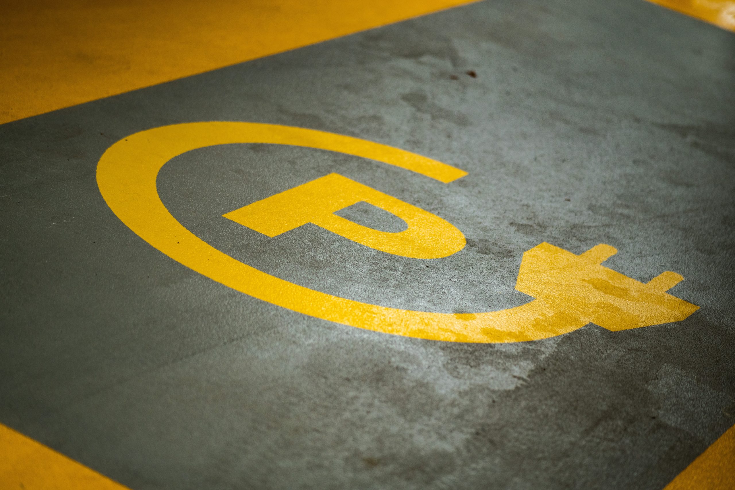 image of a parking spot for electric vehicle charging with a P surrounded by an electrical cord symbol